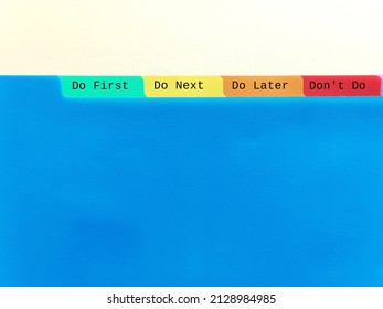 Document folder on copy space blue background with tag DO FIRST DO NEXT DO LATER DON'T DO, concept of time management skills, knowing priority of tasks, difference between important and urgent tasks
