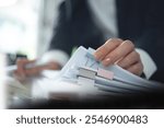 Document management. Businesswoman working with stack of paper files for searching and checking corporate files, document achieves on folders paper on office table, closeup