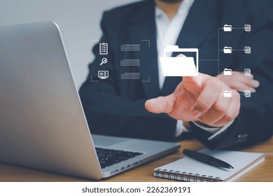 Document management system concept, Businessman pointing folder icon on virtual screen data management and business graph development,business man using laptop access files document on viritual screen - Shutterstock ID 2262369191
