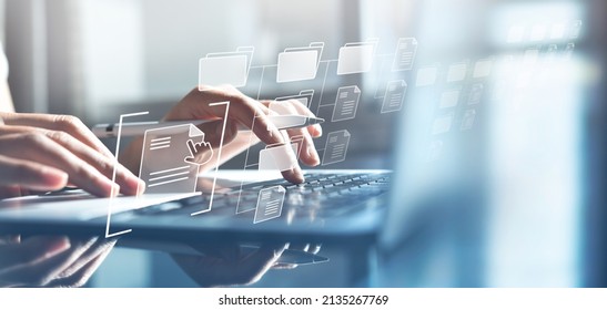 Document Management System (DMS) being setup by IT consultant working on laptop computer in office with document directory. Software for archiving, searching and managing corporate file information - Shutterstock ID 2135267769