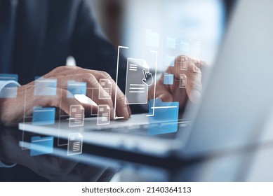 Document Management System (DMS) being setup by IT consultant working on laptop computer in office. Software for archiving, searching and managing corporate files and information