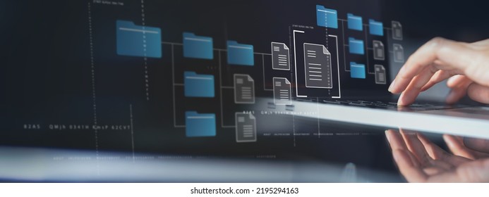 Document Management System (DMS) being setup by IT consultant working on laptop computer in office with document directory. Software for archiving, searching and managing corporate file information - Shutterstock ID 2195294163