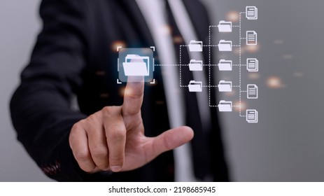 Document Management System (DMS) being setup by IT consultant working on laptop computer in office. Software for archiving, searching and managing corporate files and information
