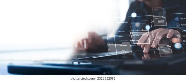 Document Management System (DMS) being setup by IT consultant working on digital tablet and laptop computer in office. Software for archiving, searching and managing corporate files and information