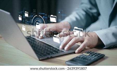 Document Management System (DMS) being setup by IT consultant working on laptop computer in office. Software for archiving, searching and managing corporate files and information