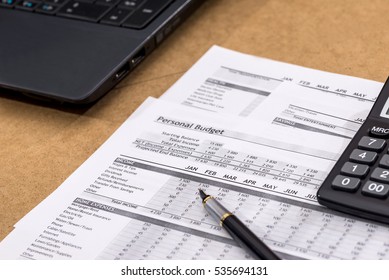 Document - Personal Budget with a laptop, a calculator and a river on wooden table. - Shutterstock ID 535694131