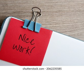 Document with red note compliment in handwriting NICE WORK, concept of giving positive feedback praise in response to a job well done, compliment to staff from boss or client, from teacher to student