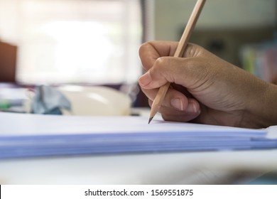 Document Report and business busy Concept: Businessman Manager hands holding green pencil for checking and signing white documents reports papers of paper files in modern office and people background.
