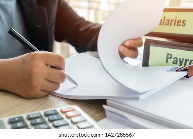 Document Report Or Business Management Concept: Businessman Manager Hands Holding Pen For Reading, Signing Paperwork Near Payroll Salary Binder, Summary Report HR-human Resources Business Bookkeeping