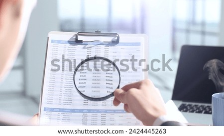 A document verification, magnifying glass, important report