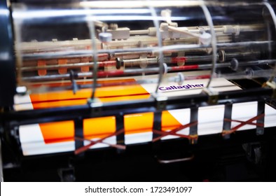 Documentary Photography Of A Commercial Printer: Detail Of A Heidelberg Printer With Print Work Going Through It