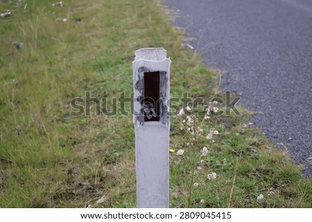 A documentary-style photograph of reflective guide posts installed beside a sealed transport corridor in suburban and regional Australia. Captured in natural daylight, the images showcase durable delineators positioned along grassy verges to improve visibility, define pavement edges and assist motorists with navigation during poor weather and low-light conditions. Their simple cylindrical design and reflective panels demonstrate an important element of traffic guidance and public safety infrastructure used throughout the country. The composition highlights practical engineering solutions that support everyday travel while documenting common features of Australia's transport system. Suitable for civil engineering references, government publications, traffic safety campaigns, educational resources, mapping projects, municipal planning documents, infrastructure reports, editorial articles and transport industry material. The authentic documentary perspective provides commercial and editorial value for projects exploring navigation, engineering standards, public works, regional connectivity, highway maintenance and essential community infrastructure.