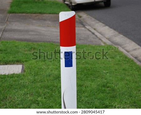 A documentary-style photograph of reflective guide posts installed beside a sealed transport corridor in suburban and regional Australia. Captured in natural daylight, the images showcase durable delineators positioned along grassy verges to improve visibility, define pavement edges and assist motorists with navigation during poor weather and low-light conditions. Their simple cylindrical design and reflective panels demonstrate an important element of traffic guidance and public safety infrastructure used throughout the country. The composition highlights practical engineering solutions that support everyday travel while documenting common features of Australia's transport system. Suitable for civil engineering references, government publications, traffic safety campaigns, educational resources, mapping projects, municipal planning documents, infrastructure reports, editorial articles and transport industry material. The authentic documentary perspective provides commercial and editorial value for projects exploring navigation, engineering standards, public works, regional connectivity, highway maintenance and essential community infrastructure.