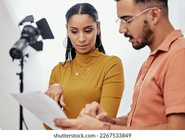 Documents, collaboration or planning with a photographer and model talking in a studio for creative production. Teamwork, designer or fashion with a designer man and woman at work on a magazine shoot - Powered by Shutterstock