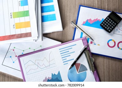 Documents with graphs and charts on table