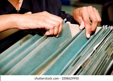 Documents In The Office : Search The File History Of Work In The Drawer : Woman Is Using Hand Searching For Work File In Drawer, Filing Cabinet.

