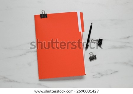 Documents in red folder, pen and binder clips on white marble table, flat lay