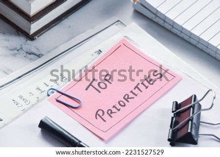 Documents with Top priorities note on office desk. Business concept, selective focus.