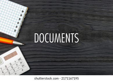 DOCUMENTS - word (text) on a dark wooden background, notepad. Business concept (copy space).