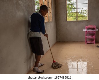 Dodoma, Tanzania. 08-18-2019. A black girl is cleaning the floor of her classroom with soap in a basic school in a rural area in Tanzania