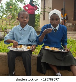 Dodoma, Tanzania. 08-18-2019. Two muslim black students are having lunch at a rural school after class activities in Tanzania.