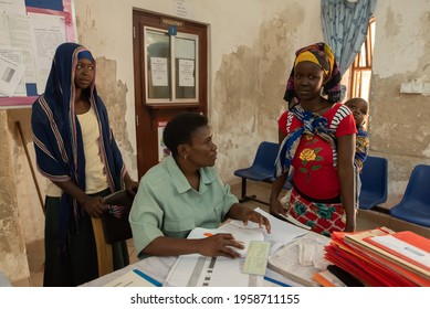 Dodoma, Tanzania. 10-10-2018. Black Muslim Staff From A Rural Hospital Are Working At The Entrance Of The Clinic Receiving A Young With Her Child Who Needs Medical Assistance.