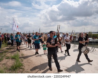 Doel, Belgium, 21 August 2022, Street Musicians With Bagpipes And Drums Followed By A Man Carrying A Flag