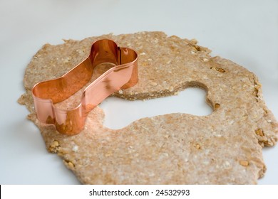 A Dog Bone Shaped Cookie Cutter And Treat Dough.