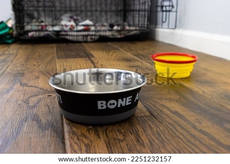 Dog bowls on the floor outside a pet crate