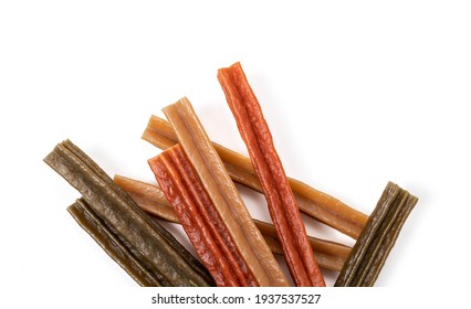 Dog dental chew sticks, top view. Multiple vegetarian and grain free dog treat sticks for stronger teeth, better gums and breath. Dental health treats for dogs. Selective focus. Isolated on white.