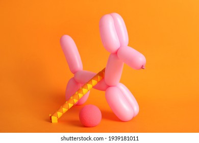 Dog Figure Made Of Modelling Balloon And Chinese Finger Trap On Orange Background