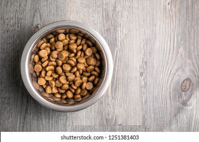 Dog Food Or Kibble In A Metal Bowl On A Wood Floor