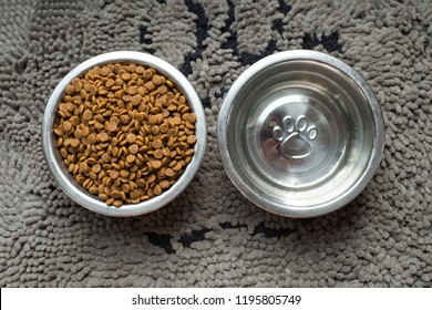 Dog Food And Water Bowls On A Rug Shot Overhead.