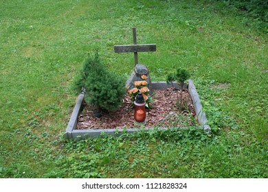 A Dog Grave On Grass Field.