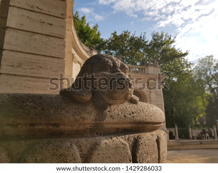 Dog head sculpture on the edge of a large stone bowl in 19. century city park Marchenbrunnen