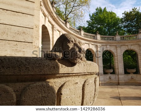 Dog head sculpture on the edge of a large stone bowl in 19. century city park Marchenbrunnen