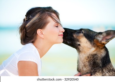 Dog Is Licking A Face Of A Young Beautiful Woman