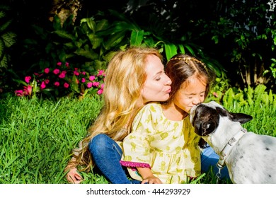 Dog Licking Girl's Face In Garden