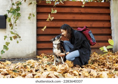 dog licks the face of his female owner on a walk near the house - Shutterstock ID 2283640337
