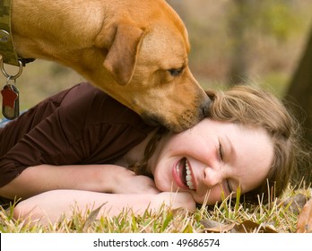 Dog Making Girl Laugh On Grass