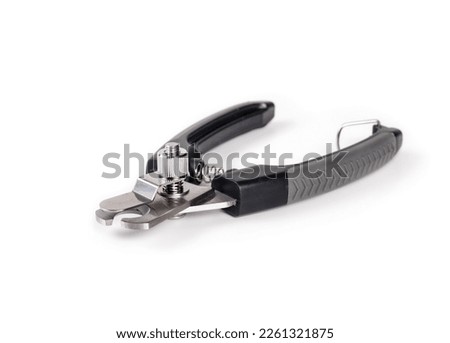 Dog nail trimmer with open blades. Black scissor style clipper with two stainless steel blades. Used by groomers and pet owners to keep dog claws short. Isolated on white. Selective focus.