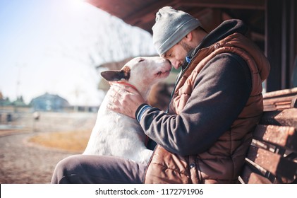 Dog owner enjoying in moments of love and happiness with his bull terrier. Pets and animals concept