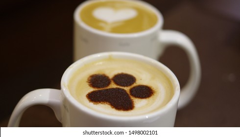 Dog paw pattern and heart shape latte art coffee in white mugs - Powered by Shutterstock