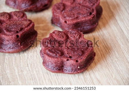 dog treat. pastry food for cat. appetizing dog muffins on wooden background. dog birthday. red velvet. paw shaped dog treat. homemade pet biscuit. paw bakery cookie. pet cake. selective focus.