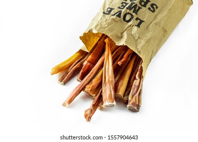 Dog Treats. A Batch Of Natural Dog Treats, Bully Sticks, In A Paper Bag On White Background. Paper Bag Printing Says, Love Me.