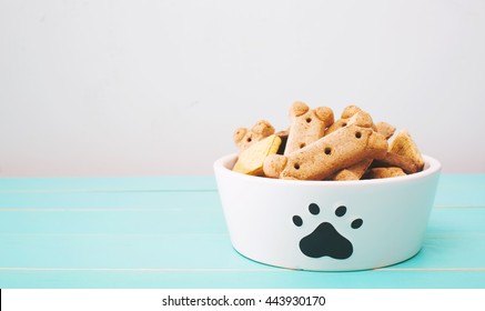 Dog treats in a bowl on wooden table - Shutterstock ID 443930170