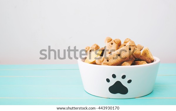 Dog treats in a bowl on\
wooden table