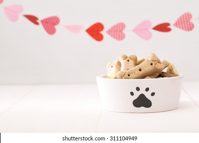 Dog Treats On A White Bowl With A Garland Of Hearts