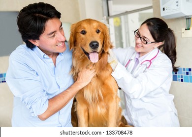 Dog At The Vet With His Owner And The Doctor