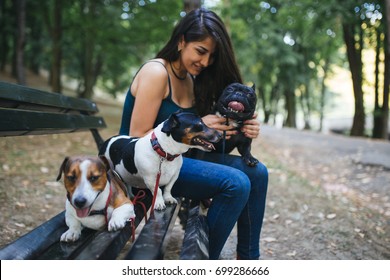 Dog walker with dogs enjoying in park.